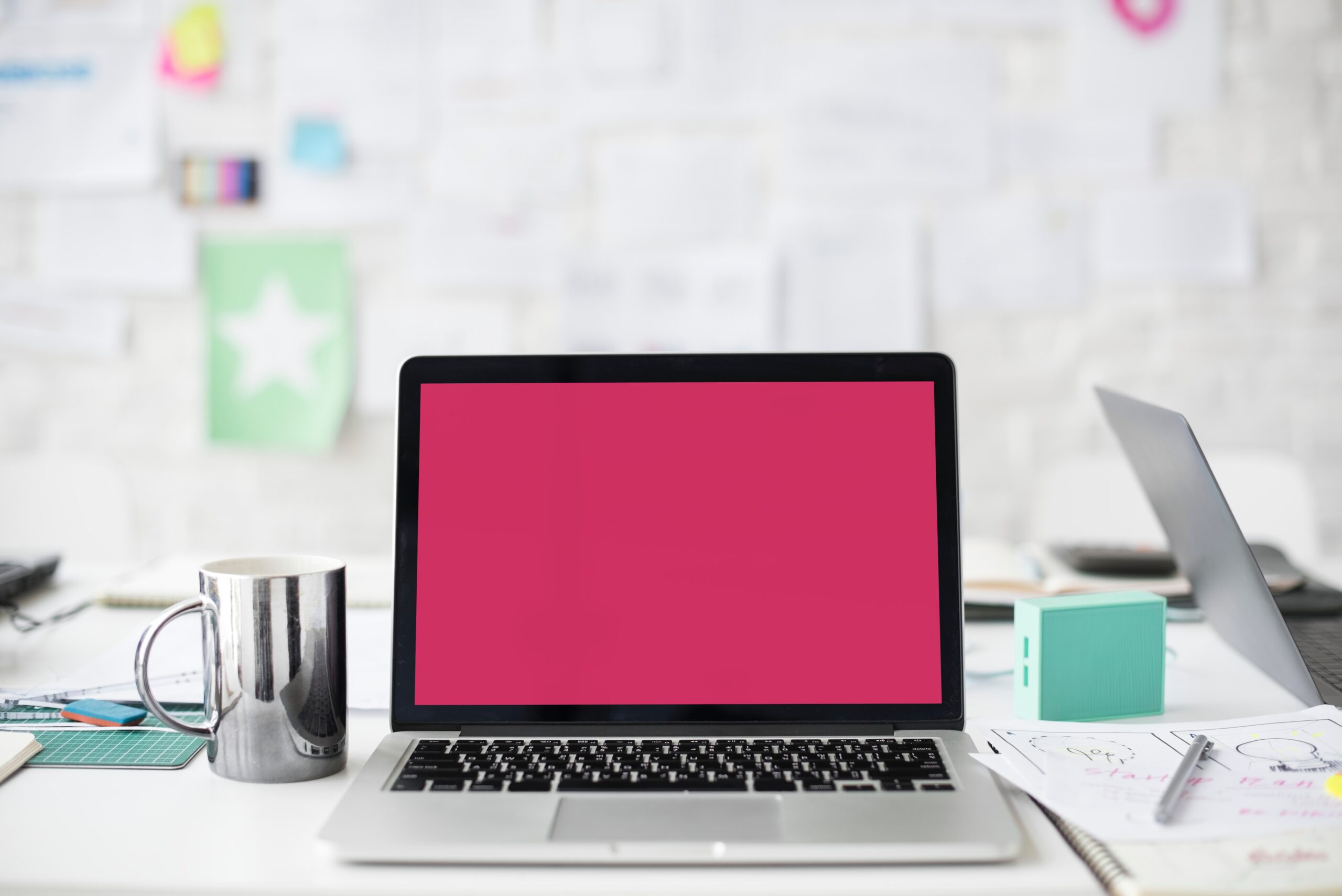 a laptop with pink wallpaper used for content creation