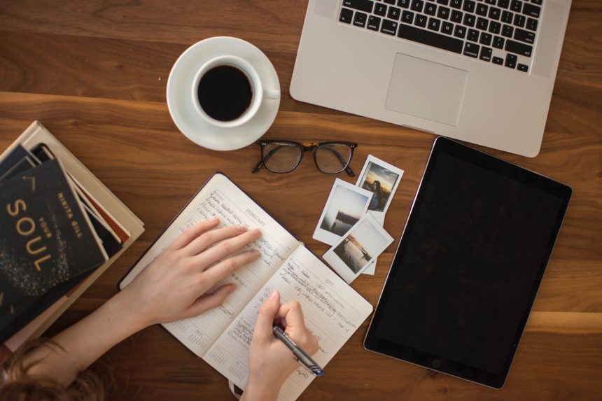 a messy table and a laptop and a list of blog writer traits