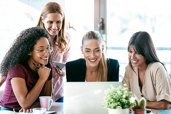 Four People Huddling in Front Laptop